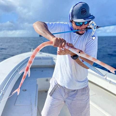 a man dragging a fish in a boat