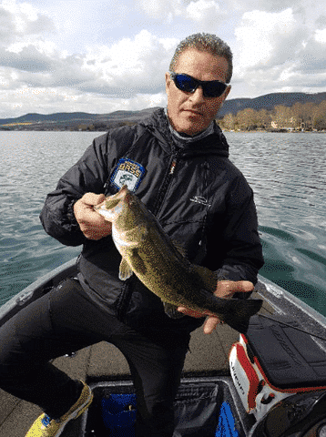 a man showing two fish in a boat