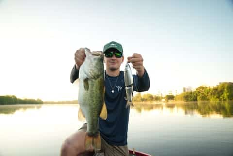 Angler holding bass and fishing lure
