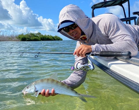 a man holding a fish in a boat