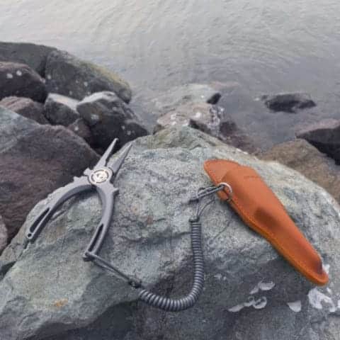 Fishing pliers on rocky surface.