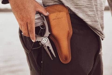 Pliers secured in holster on waist.